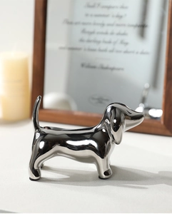 Modern silver mirror finish dachshund dog sculpture on a desk with decor