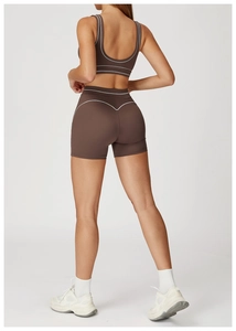 Detailed back view of brown yoga set with white contrast stitching and V-shaped seam detail