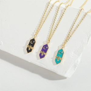 Detail of bee and moon enamel pendants with rhinestones on delicate gold chains