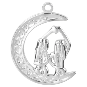 Macro shot of silver crescent moon pendant with Celtic knots and twin figure detail