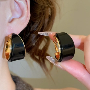 Gros plan de boucles d'oreilles en U plaquées or 18 carats avec résine noire