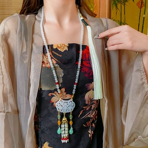 Detailed shot of an oriental tassel necklace with carved white jade and colorful beads