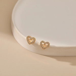 Macro shot of 18K gold plated hollow heart stud earrings with sparkling cubic zirconia pavé