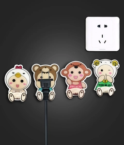 Detail of four colorful animal-shaped adhesive hooks for power plug cable management