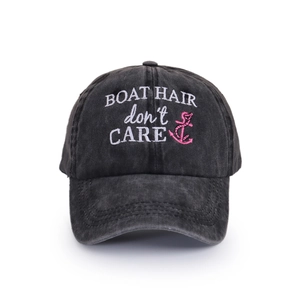 Detailed view of white BOAT HAIR embroidery on a black washed vintage baseball cap