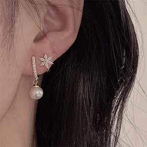 Close-up of vintage pink zircon earrings with flower ear cuff and white round pearl