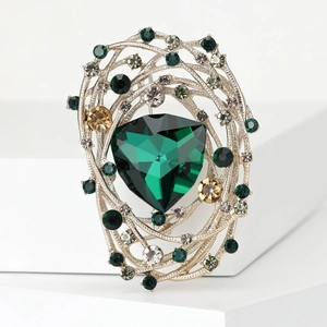 Detail of vintage bird nest brooch with green crystal and sparkling rhinestones