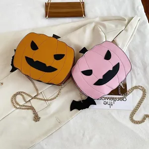 Detail of pumpkin-shaped bags in orange and pink with bat wings and chain straps