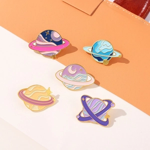 Five-piece set of planet enamel pins in pastel colors displayed on minimalist background