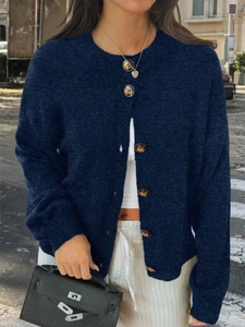 Détail du cardigan en maille bleu foncé montrant le col rond et les boutons ronds