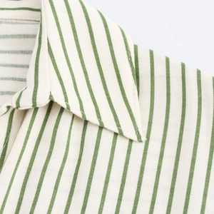 Détail du col et de la texture du tissu d'une chemise à rayures vertes et blanches