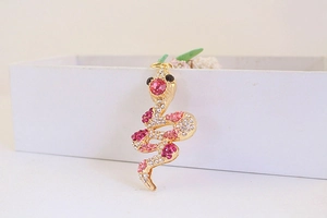 Macro shot of gold-plated snake keychain with sparkling pink and red rhinestones