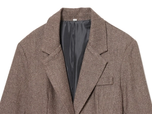 Macro view of brown herringbone wool blazer collar showing premium tweed texture