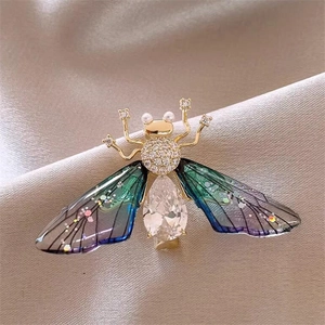 Close-up of bird brooch with gradient wings, pearls and water-drop shaped crystal