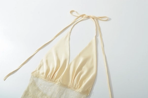 Détail du haut licou en satin de soie beige avec dentelle élégante et cordons