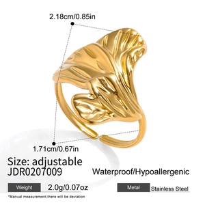 Macro view of gold flower leaf pattern on adjustable stainless steel open ring