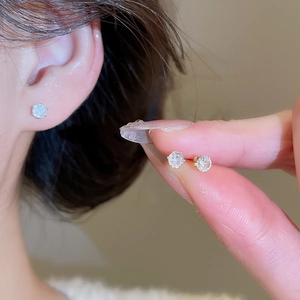 Detailed view of gold-plated stud earrings featuring brilliant round-cut cubic zirconia stones