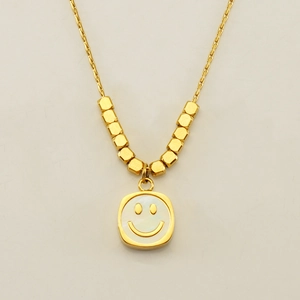Detail of gold titanium steel necklace with square smiley face pendant and cube beads