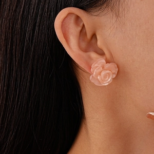 Close-up of elegant pink resin flower earrings on a model to show size and detail