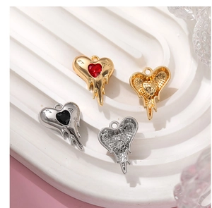 Close-up of heart-shaped lava-style charms in gold and silver with colorful rhinestones