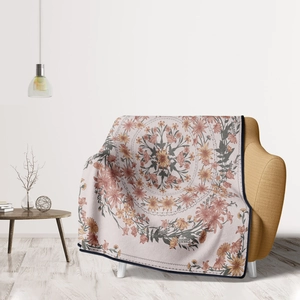 Detail of floral mandala throw blanket draped over a yellow sofa in cozy room