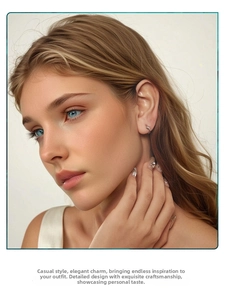 Close-up of a silver butterfly stud earring with sparkling stones on a female model