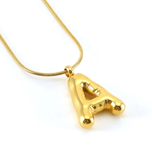 Macro shot of gold balloon-style letter A pendant on a sleek snake chain necklace