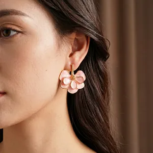 Vintage layered pink floral enamel earrings with gold accents on model's ear