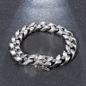 Detailed macro view of silver Cuban chain links featuring embossed skull designs on steel