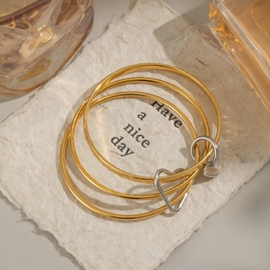 Three-piece set of 18K gold and silver layered heart charm bangles in stainless steel