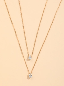 Macro view of gold layered necklace with sparkling waterdrop and oval zircon pendants