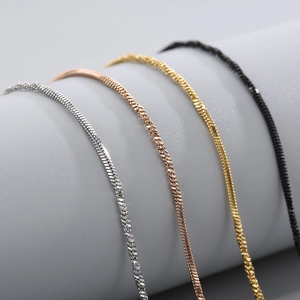 Snake chain necklaces in silver, rose gold, gold, and black finishes on a grey background