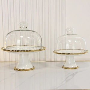 Detailed macro view of white ceramic dessert plates with elegant gold beaded rim accents