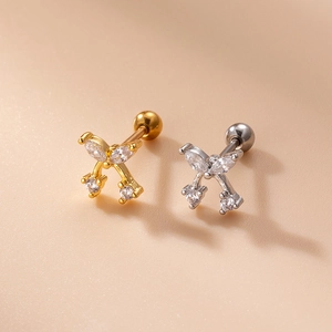 Detail of cherry-shaped stud earrings with gold and silver finish and clear cubic zirconia
