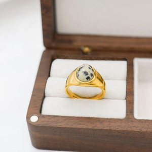 Close-up of a vintage 18k gold plated ring featuring an oval Dalmatian Jasper stone