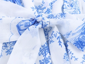 Detailaufnahme von blau-weißem Toile-de-Jouy-Muster und Taillenband mit Schleifendetail