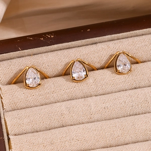 Detailed macro view of three 18K gold plated teardrop zircon rings in a beige velvet box