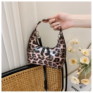 Detail of pink leopard print patent leather handbag with glossy finish and silver hardware