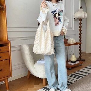 Close-up of a white lace flower tote bag styled in a cozy Nordic home interior setting