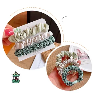 Three-piece leopard print and solid color fabric hair scrunchies set on display card