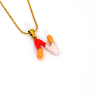 Detailed close-up of colorful enamel letter M pendant on gold stainless steel chain