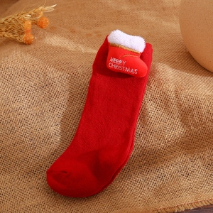 Detail of red Christmas sock with bow and Merry Christmas embroidery on burlap