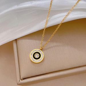 Macro view of gold-plated titanium necklace with crystal-embellished round pendant