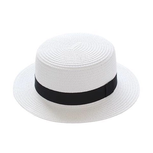 Detailed close-up of woven texture on a white straw Panama hat with black ribbon decoration