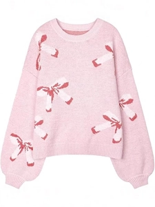 Pink oversized knit sweater featuring white and red bow patterns and casual crew neck