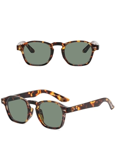 Close-up of retro tortoiseshell sunglasses with green lenses and silver diamond rivets