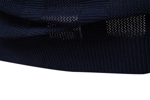 Detailed close-up of dark blue knit fabric with checkerboard texture and ribbed hem