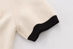 Detail view of contrast knit cuff with fine beige fabric and black ribbed edge trim