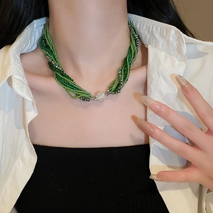 Detail of multi-strand green crystal beaded necklace with magnetic ball clasp