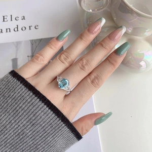 Detail of emerald-cut blue zircon ring with triangle side stones on silver band
